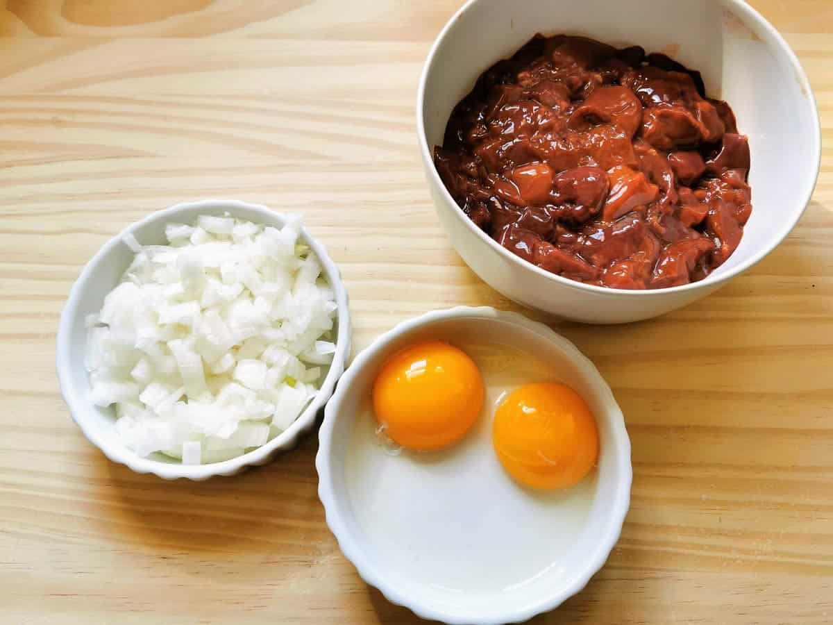 Chicken liver, egg yolks and diced onions in seperate bowls