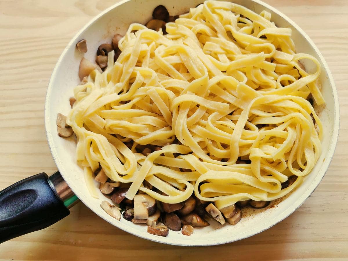 cooked tagliatelle in pan with mushrooms