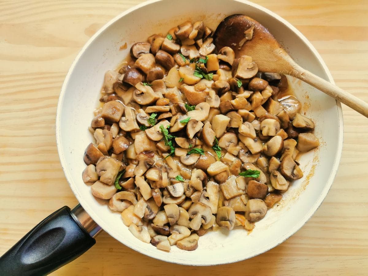 porcini and cremini mushrooms cooking in frying pan