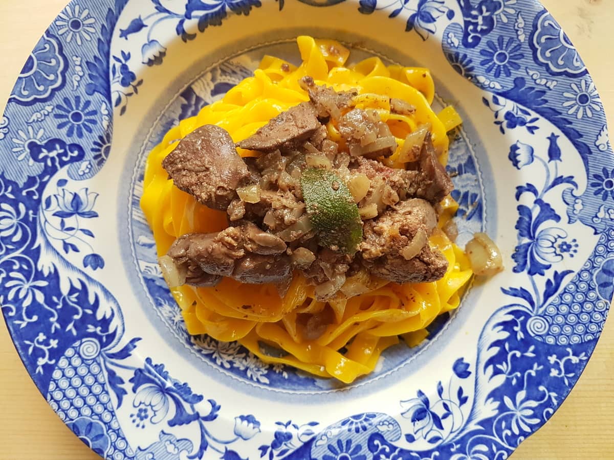 Tagliatelle with chicken liver and sage garnish.