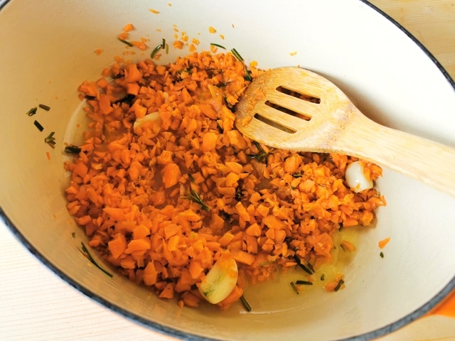 chopped carrots, garlic and rosemary cooking in Dutch oven