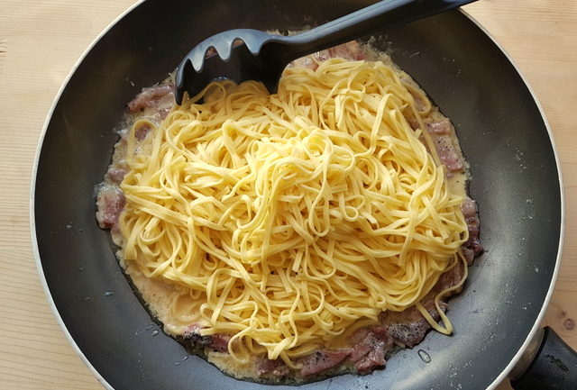 cooked tagliolini with San Daniele sauce in frying pan