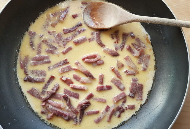 prosciutto di San Daniele with cream cooking in frying pan