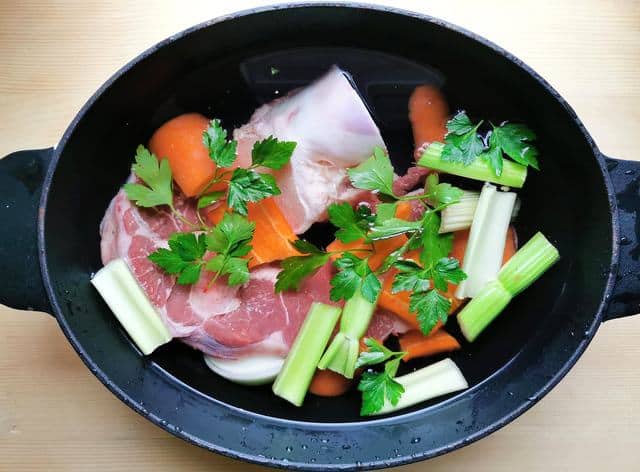 prepared beef broth ingredients in Dutch oven with water