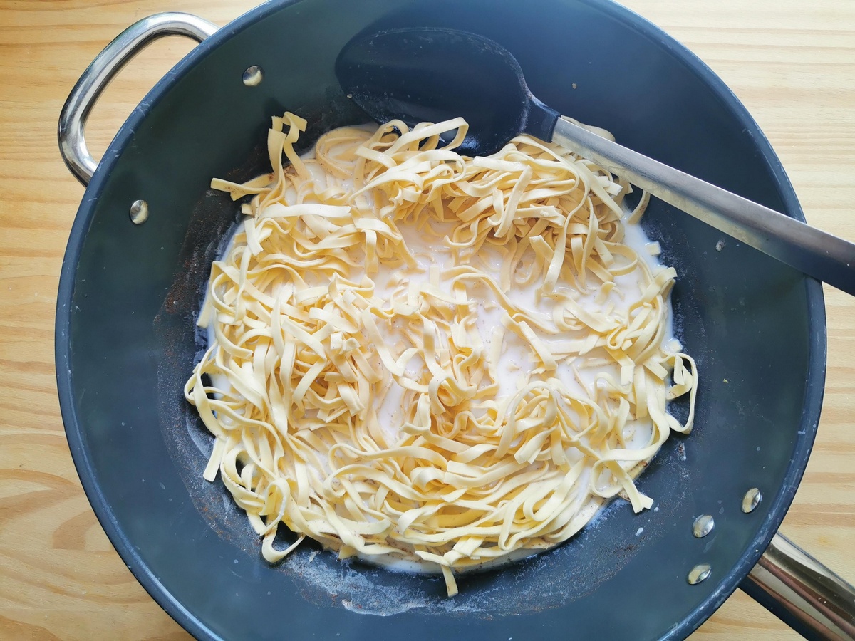 Fresh tagliolini added to sweetend milk in deep skillet.