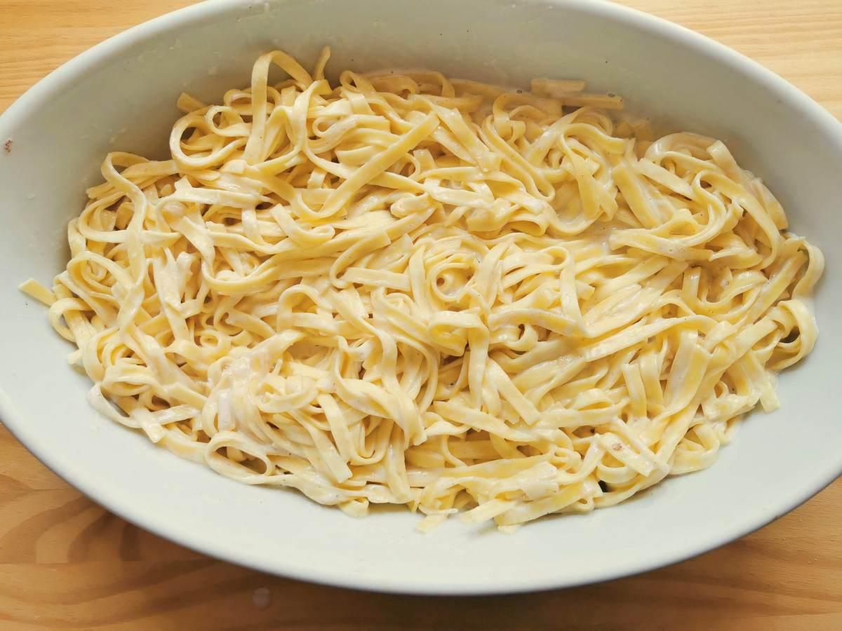 Ready tagliolini cooked in sweetend milk in white oval ceramic dish.