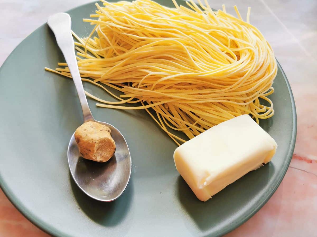 Main ingredients for tagliolini with white truffle on green plate.