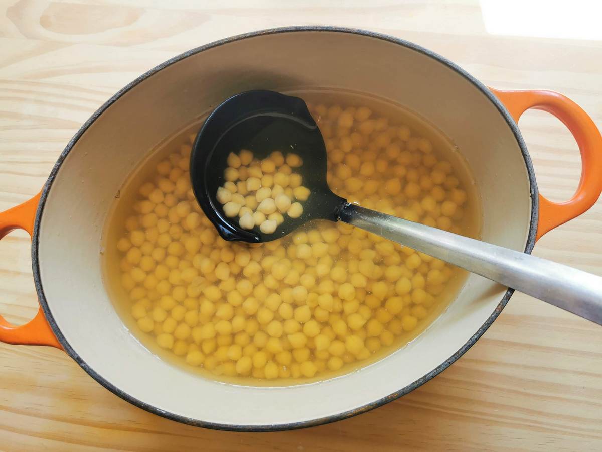Dried chickpeas cooked in water in Dutch oven.