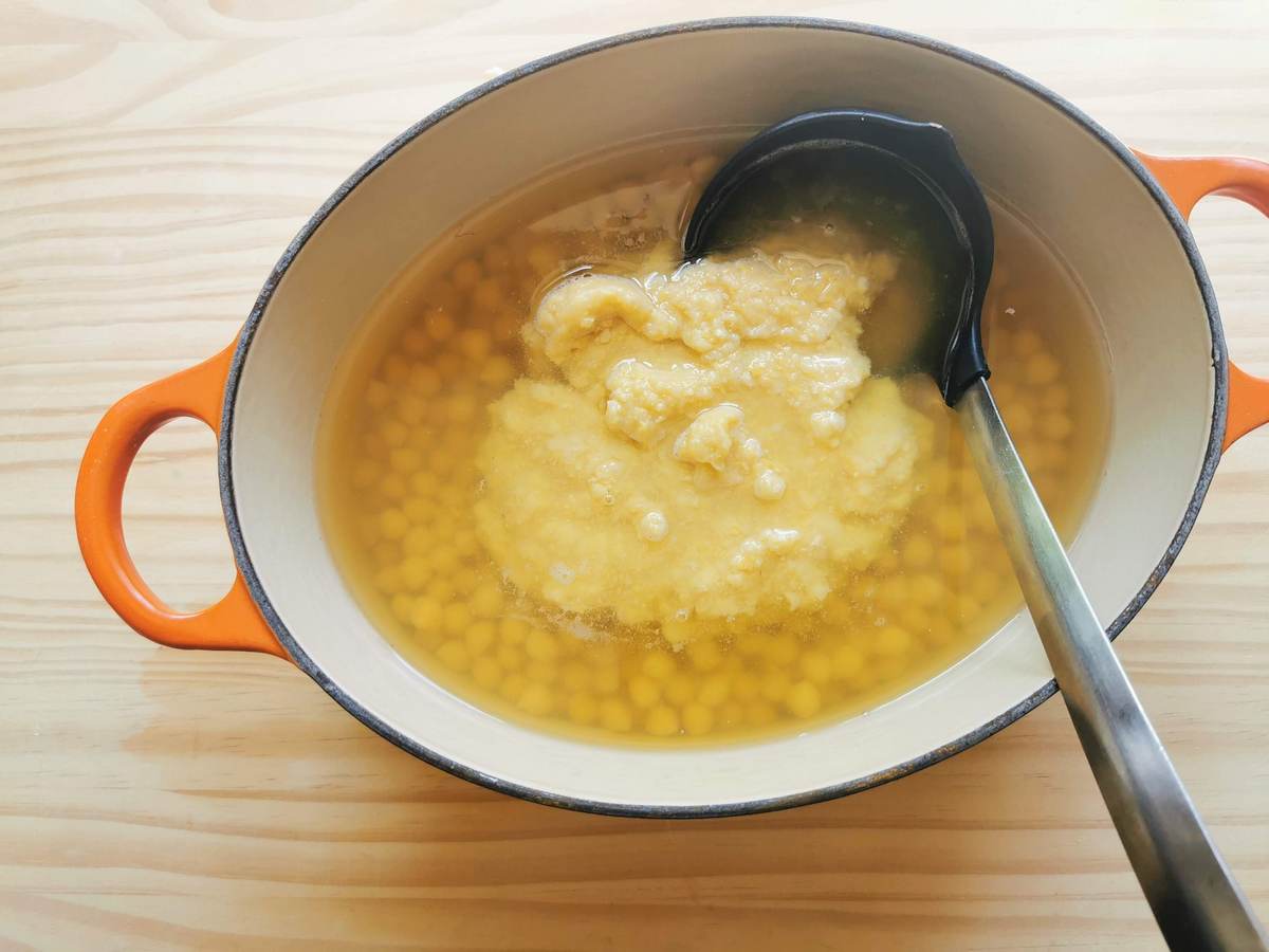Puréed chickpeas added to cooked chickpeas in Dutch oven.