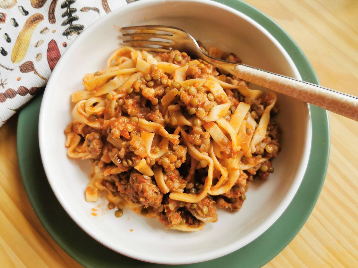 Portion of Umbrian lentil and sausage pasta in white bowl.