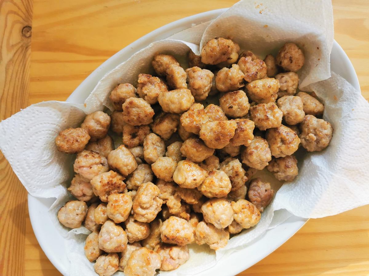 Browned small meatballs in bowl lined with kitchen papaer.