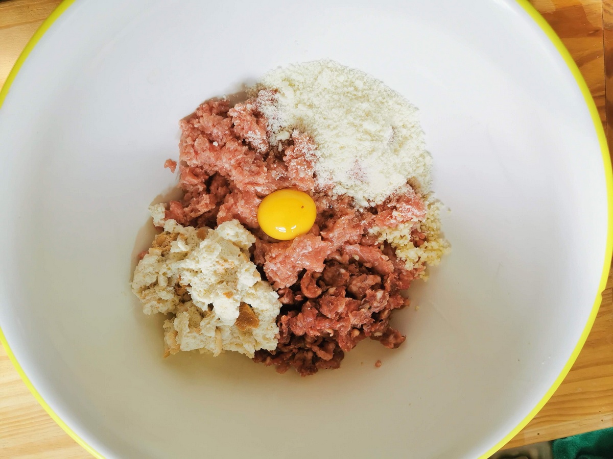 Ingredients for pork and sausage meatballs in large bowl.