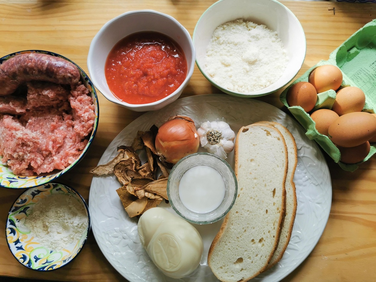 Ingredients for baked ziti alla lucana on large white plate.