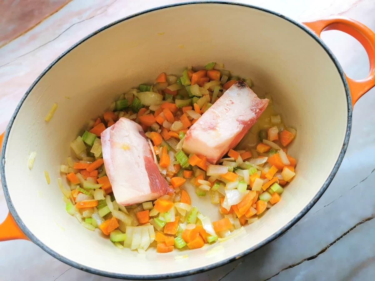 beef bones in Dutch oven with chopped vegetables