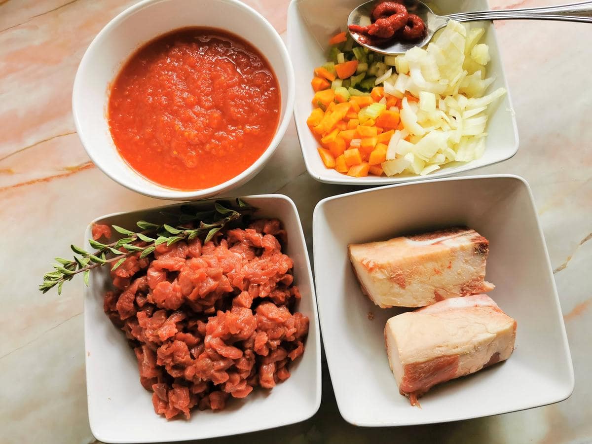 prepared and chopped sauce ingredients in white bowls