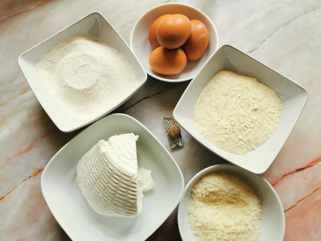 ingredients for ravioli dough and filling in white bowls