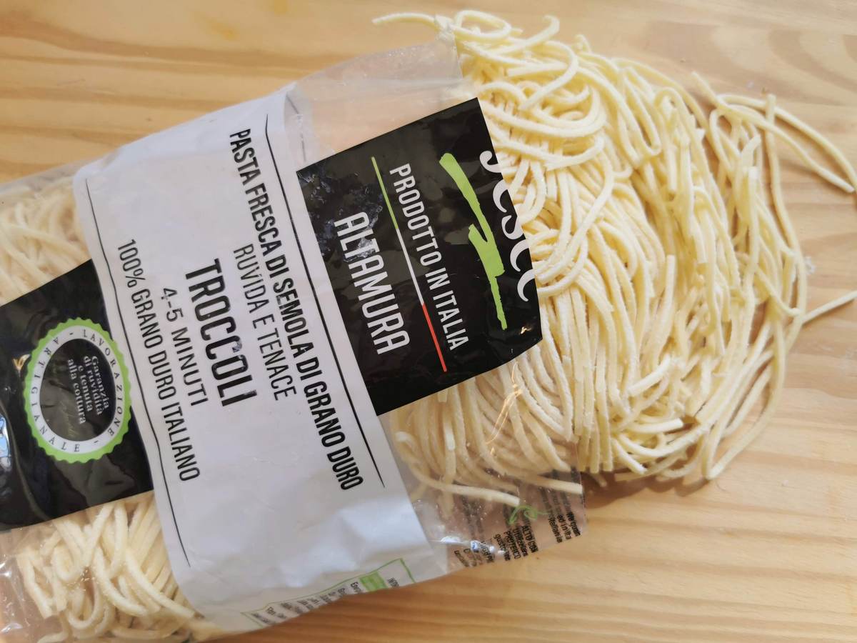 Fresh troccoli pasta on wood worktop.