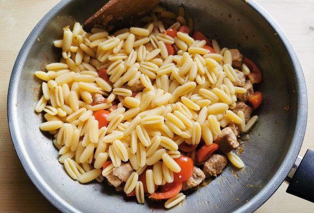 cooked malloreddus (sardinian gnocchi) in frying pan with tomatoes  and tuna