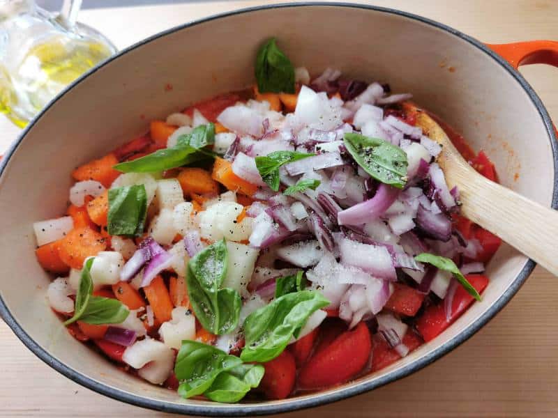 basil, onion, carrots and celery added to tomatoes in Dutch oven