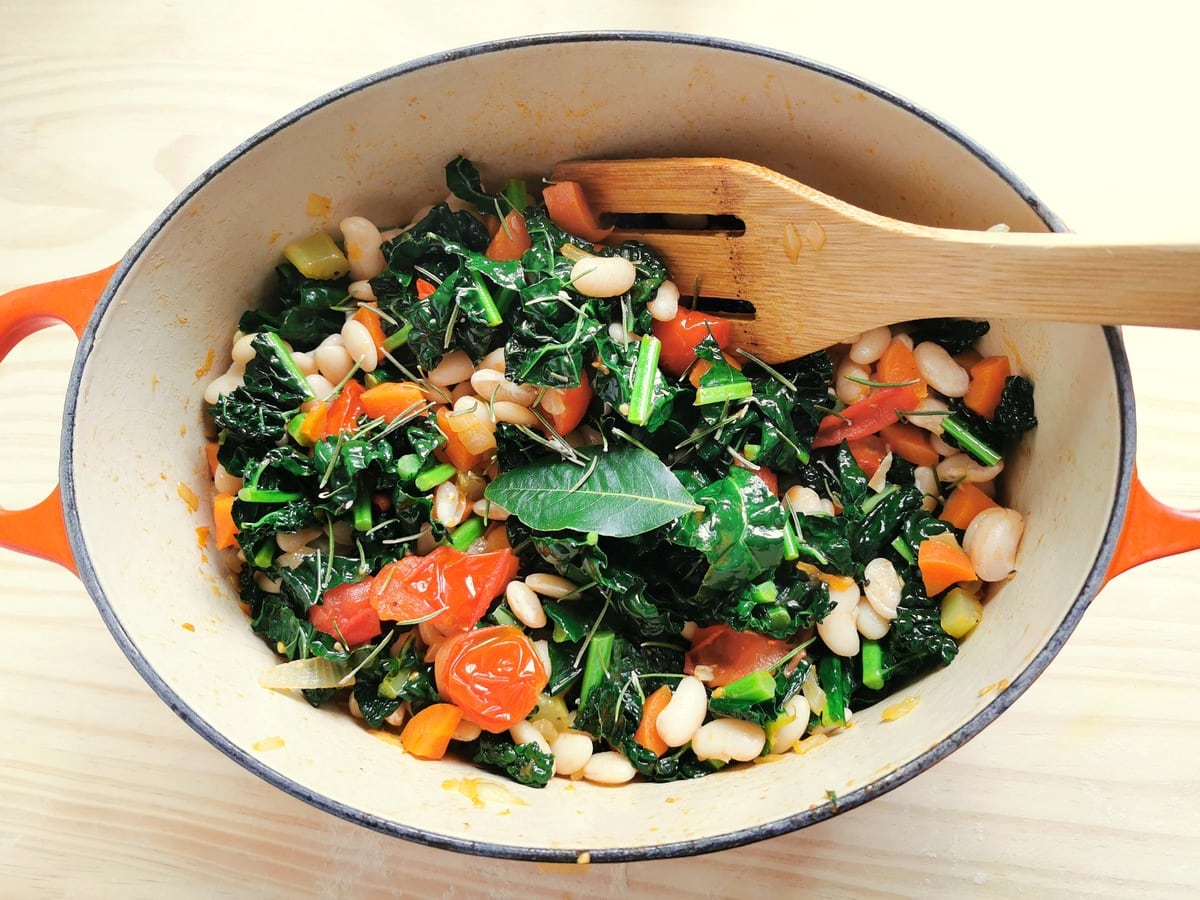 vegetables and beans or kale and cannellini soup mixed together in Dutch oven