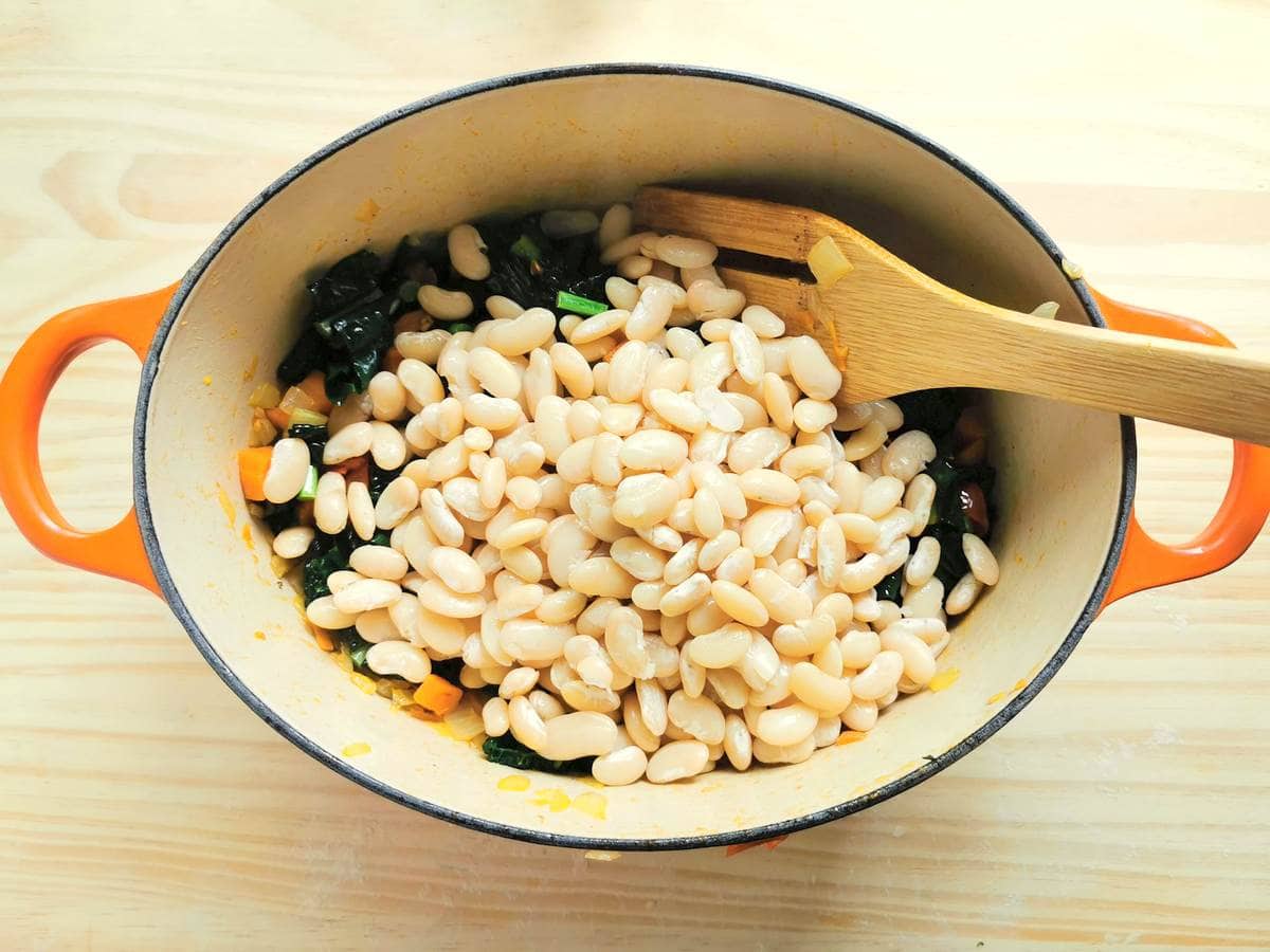 cooked cannellini beans in Dutch oven with other soup ingredients