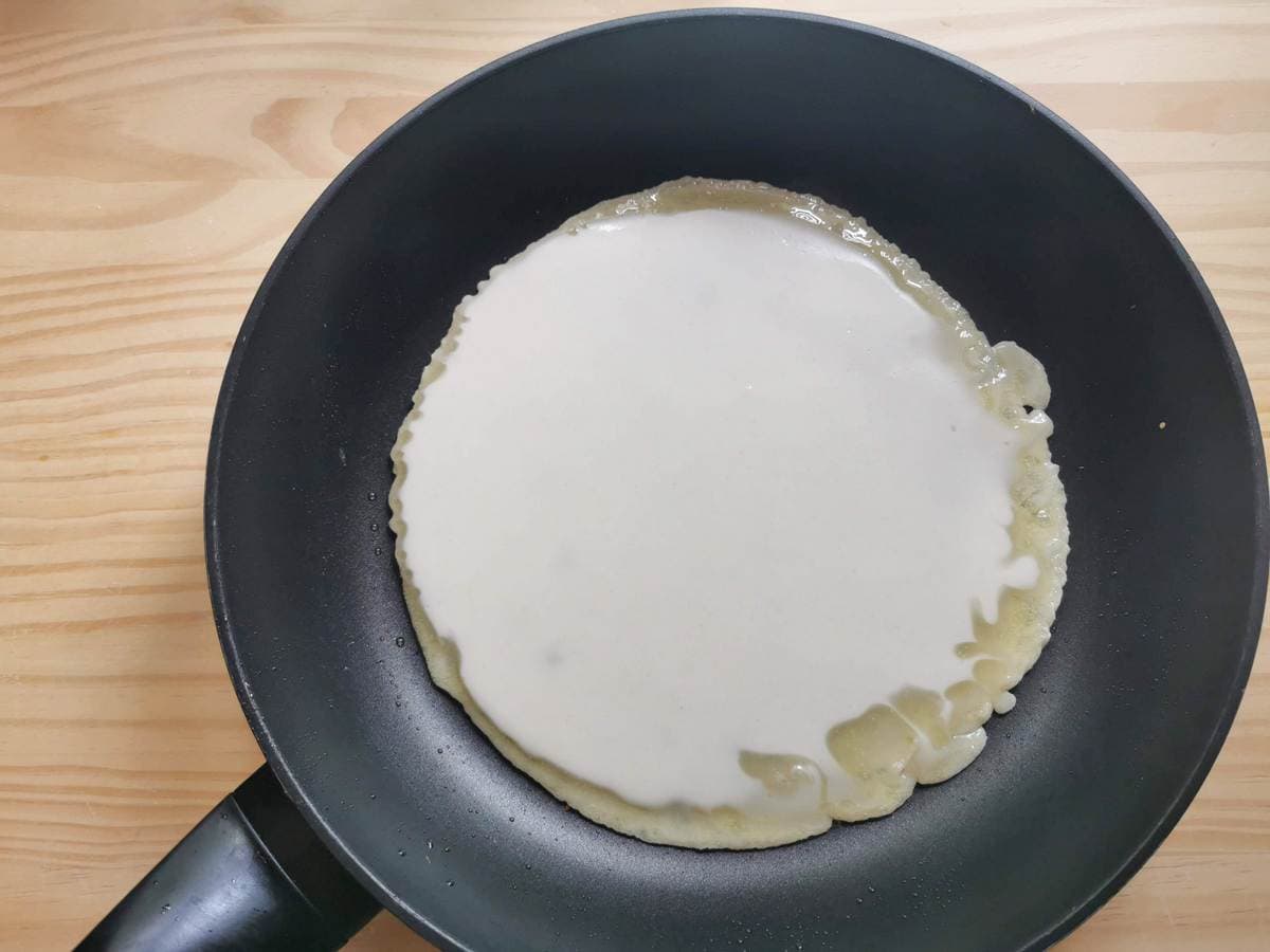 Testaroli batter spread over bottom of hot skillet.