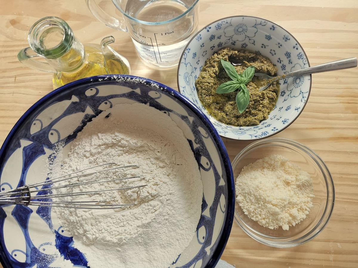 Ingredients for testaroli with pesto on wood work top.
