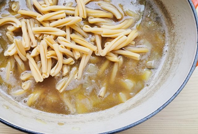 casarecce pasta added to wild pea soup in Dutch oven