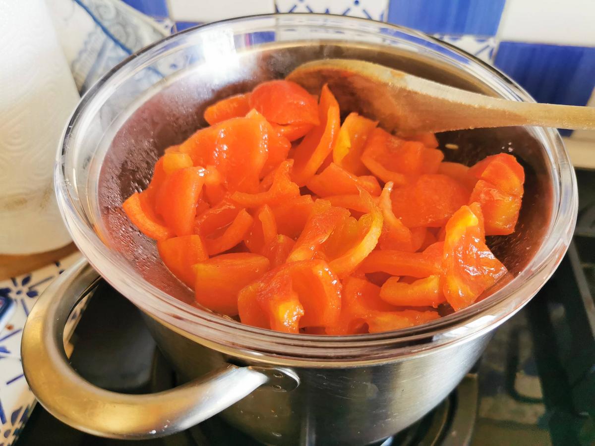Peeled fresh tomato pieces and garlic in glass bowl cooking in Bain Marie.