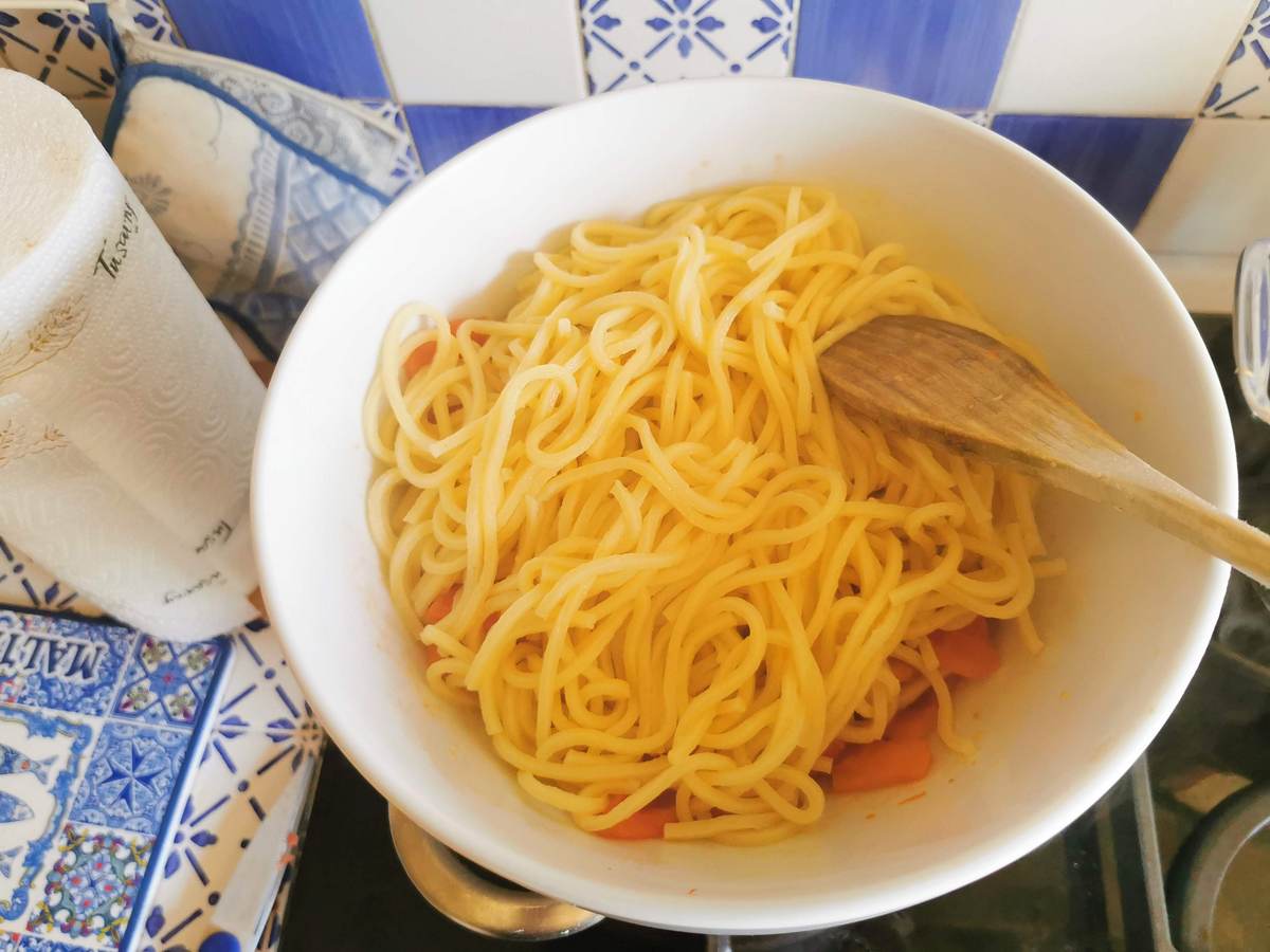 Cooked troccoli pasta added to tomatoes in bowl over Bain Marie.