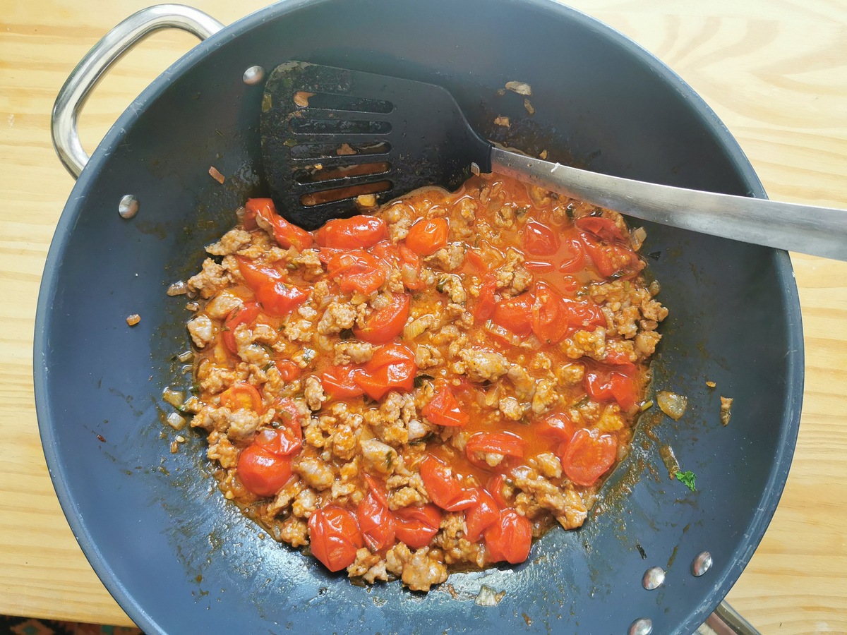 Luganega sausage ragu cooking in large skillet.