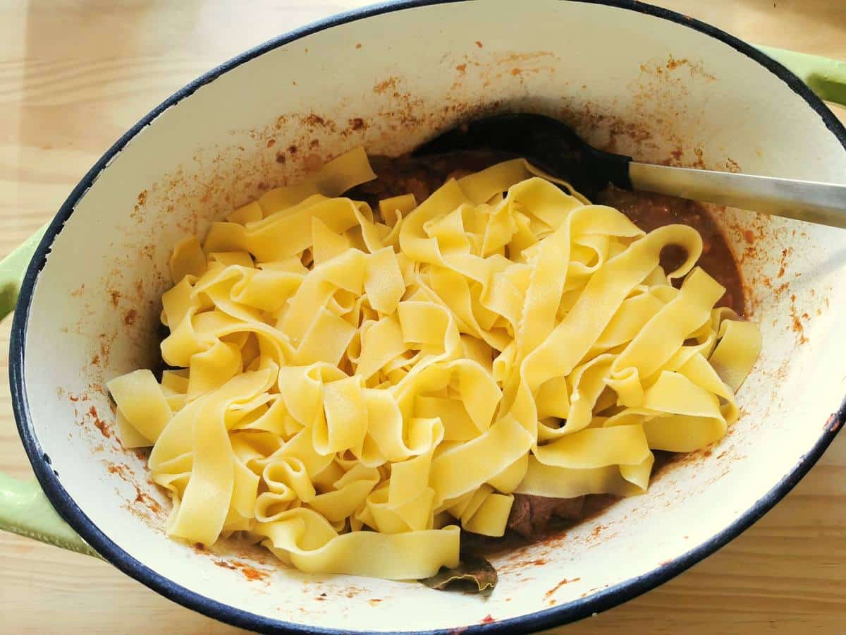 Adding pasta to the venison ragu.