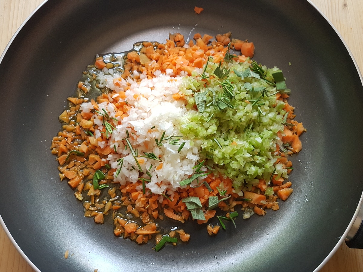 Chopped carrots, onion, celery, sage and rosemary in a skillet.