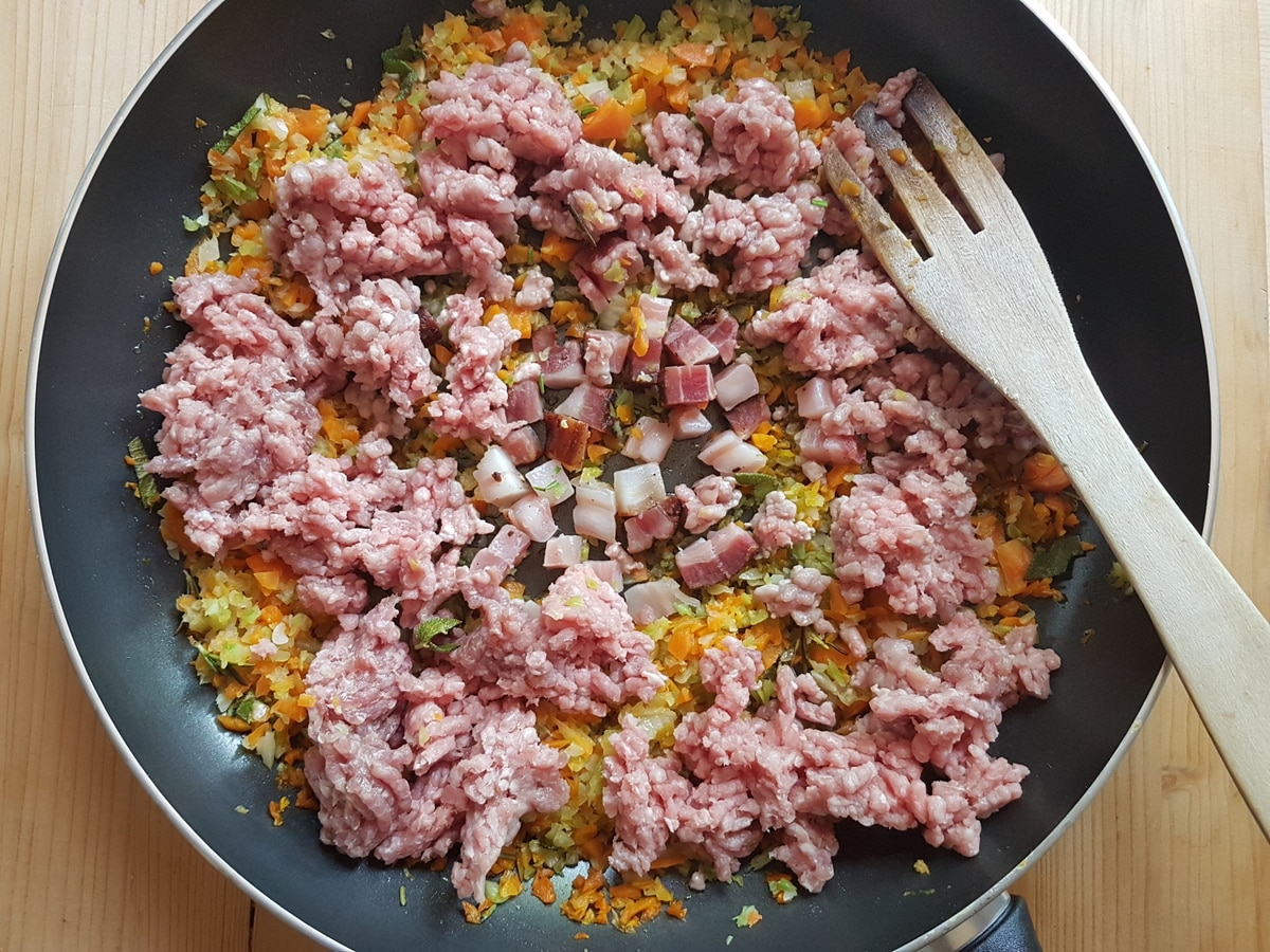Ground meat and pancetta added to the softened vegetables.