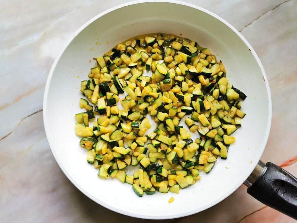 ready fried zucchini cubes in frying pan.