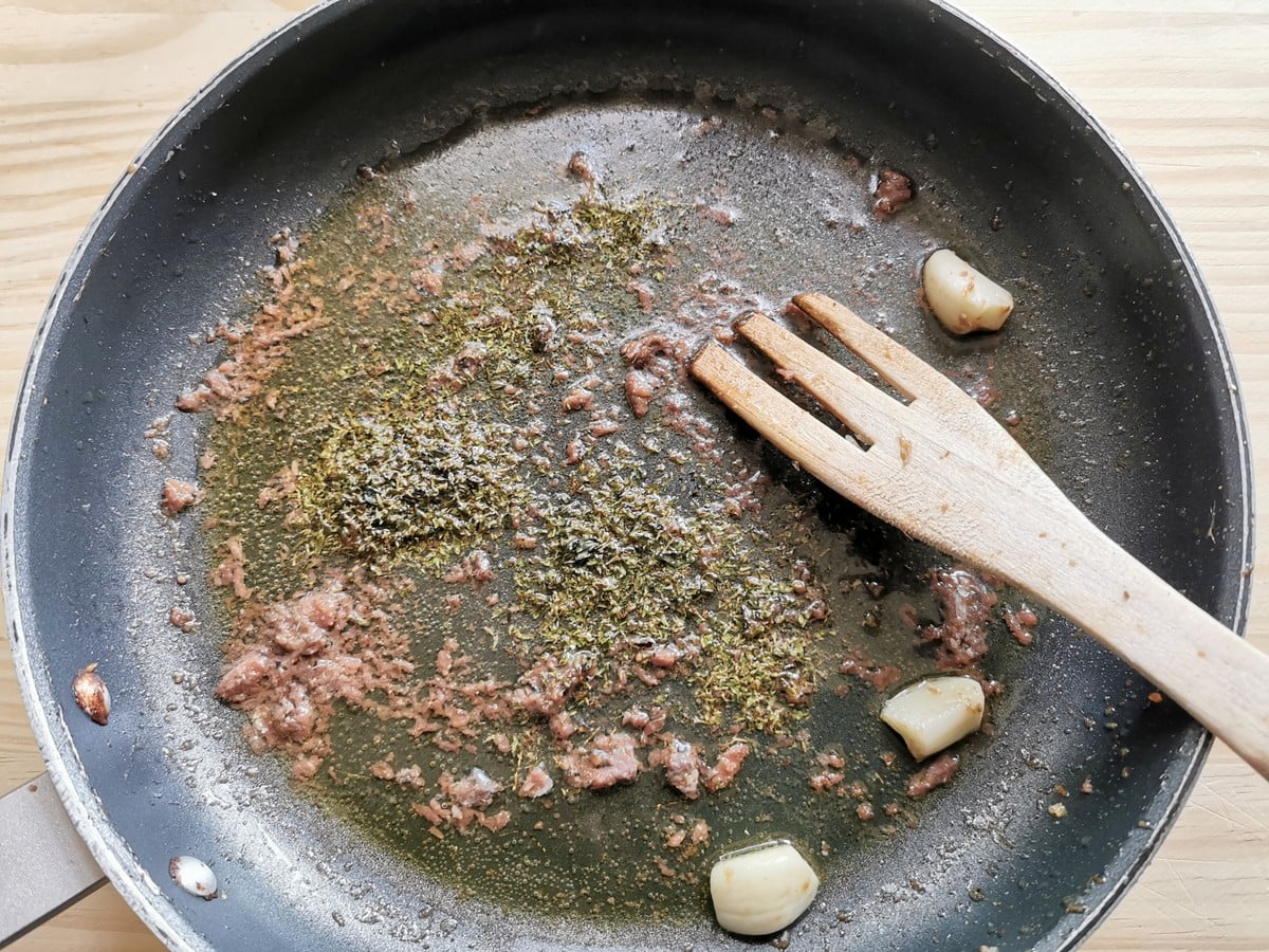 Dried oregano in pan with anchovies and garlic.