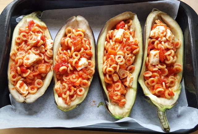 eggplant boats filled with pasta and sauce in oven dish