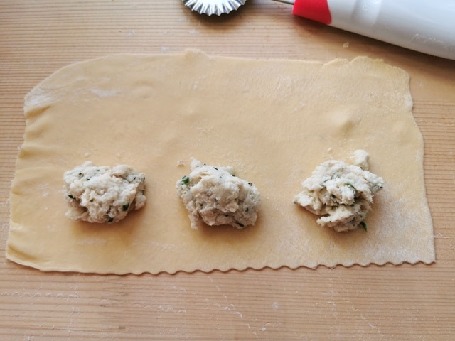 tablespoons of fish filling on homemade pasta sheets