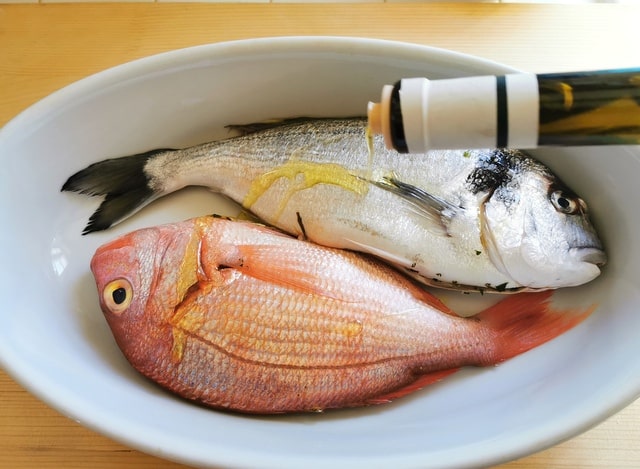 a small bream and a small snapper in white oven dish