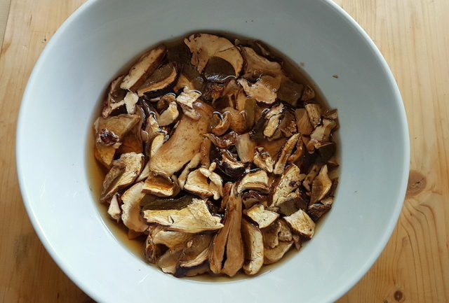 dried porcini soaking in white bowl in warm water