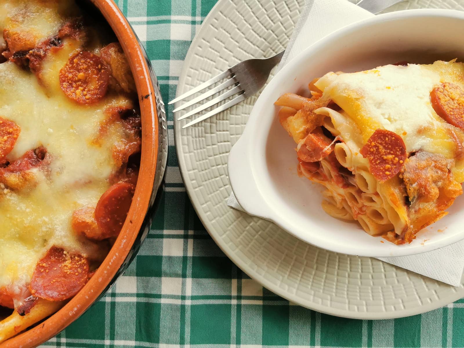 One serving of baked ziti with sausage on a kitchen table.
