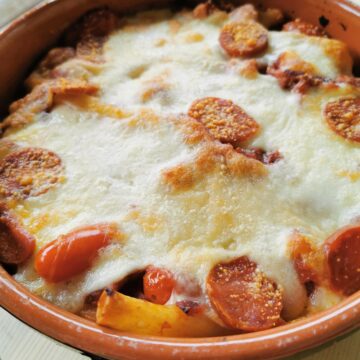Spicy sausage and ziti pasta in a baking dish.
