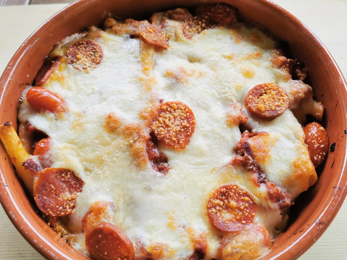 Baked ziti with sausage in a dish.