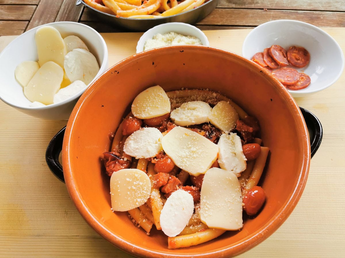 Layering the sausage and ziti in a baking dish.