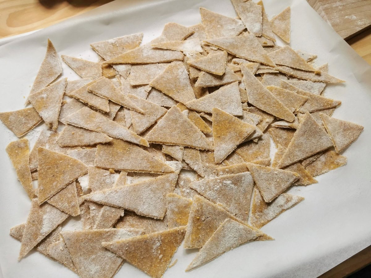 Ready uncooked blecs buckwheat pasta triangles on flour dusted kitchen paper.