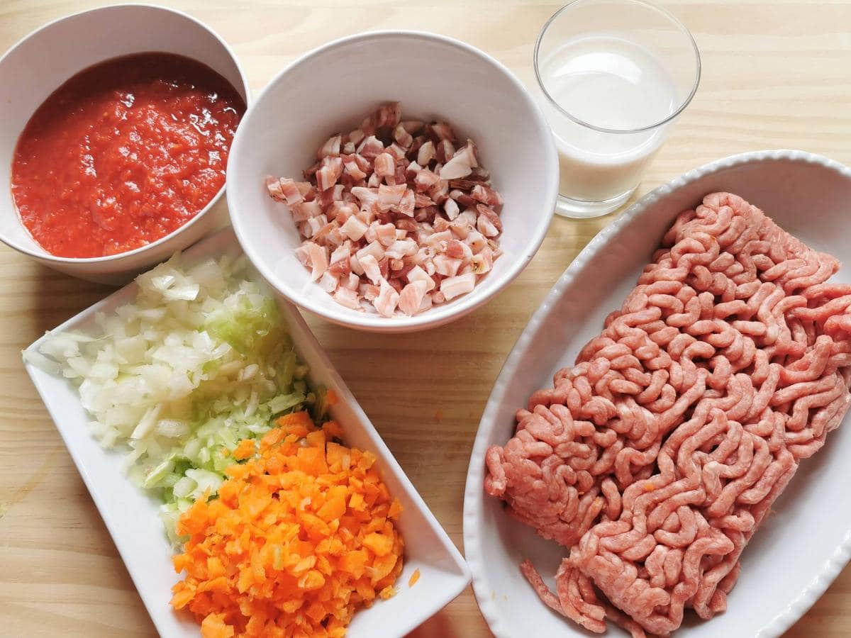 Prepared ingredients for Bolognese: pancetta cut into small cubs and carrots, onion and celery cut into small pieces.