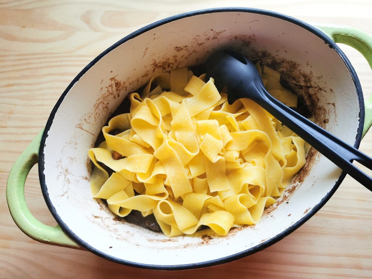 Cooked pappardelle in Dutch oven with ragu.