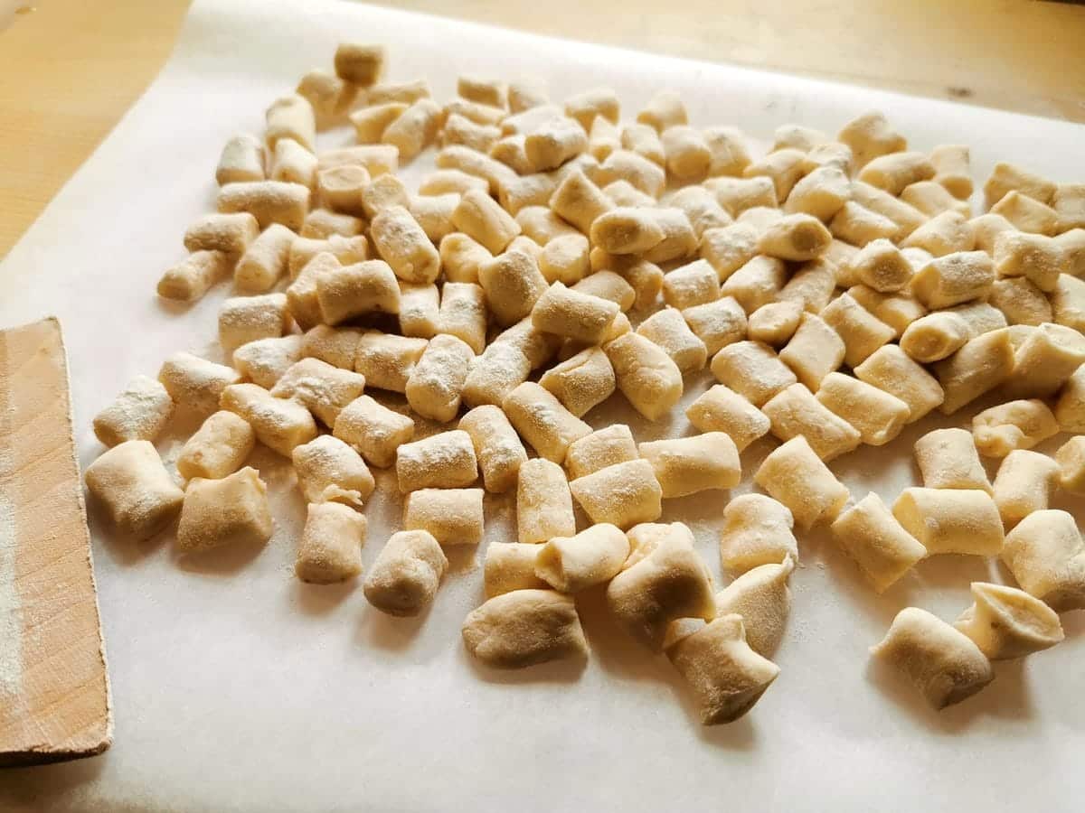 Ready uncooked bread gnocchi on floured tray.