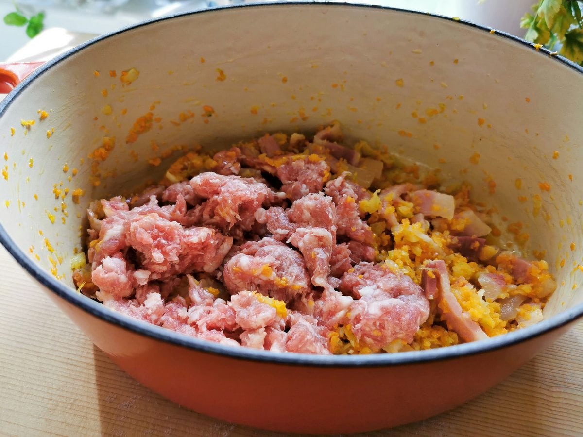 sausage meat and guanciale in Dutch oven with sautéed veggies