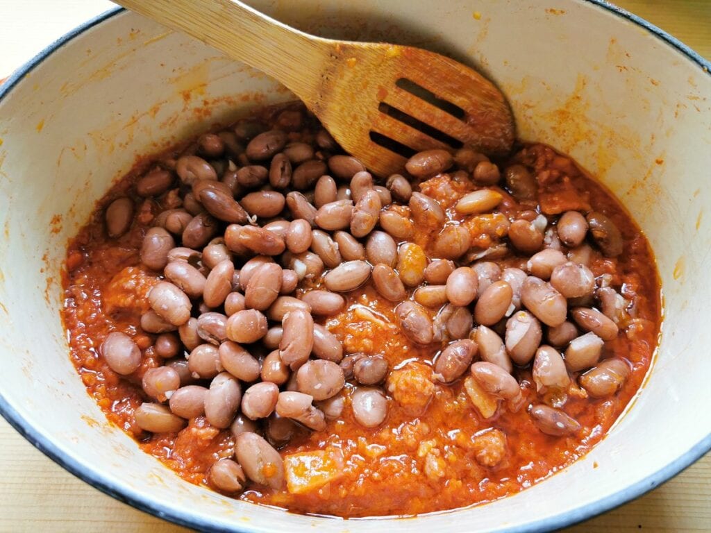 cooked borlotti beans added to the sauce in Dutch oven